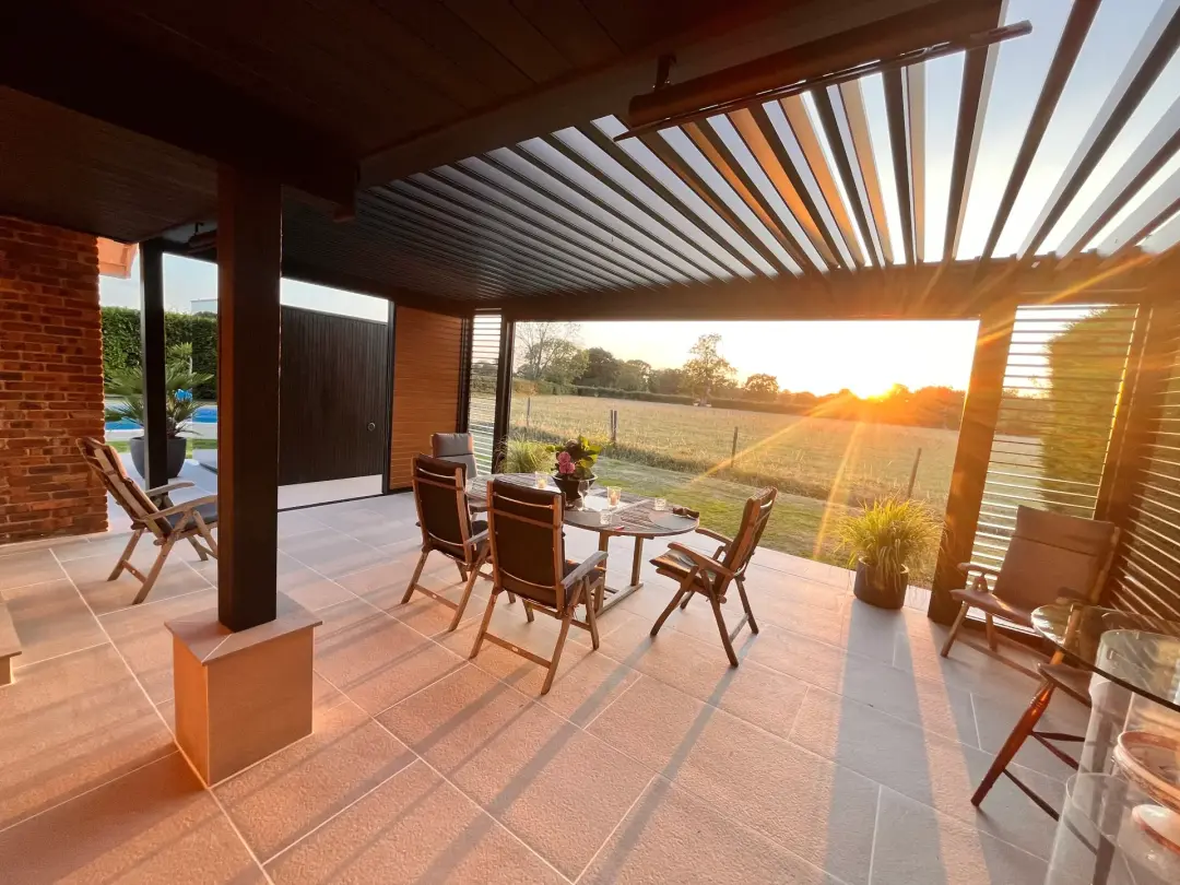 Finished porcelain patio beneath a contemporary pergola at sunset
