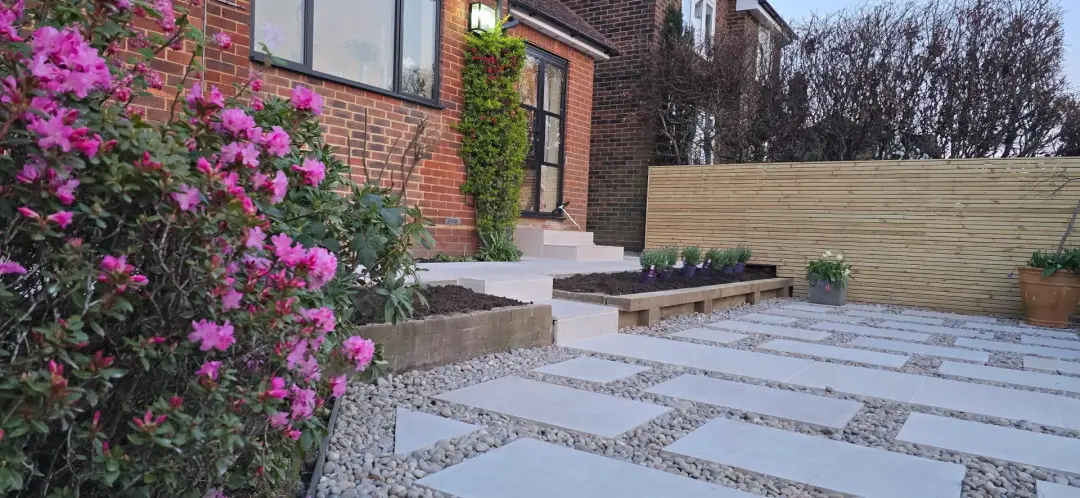 Completed contemporary garden with porcelain paths, pebbles and spring planting